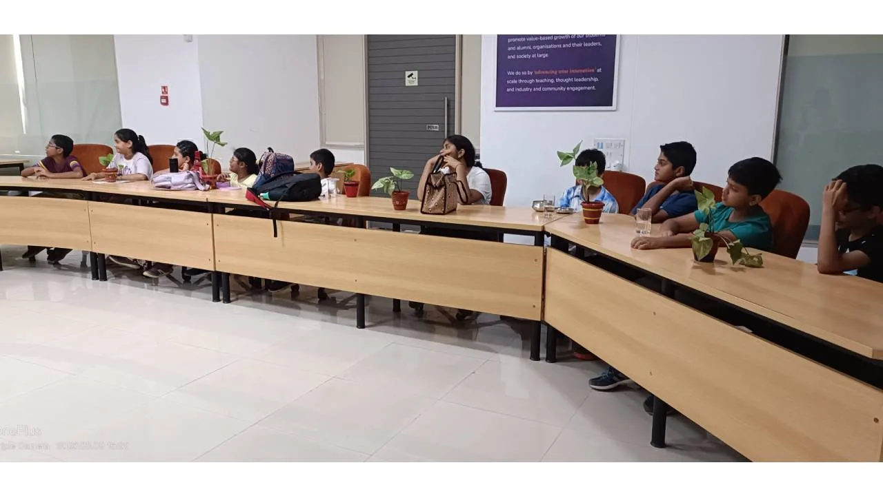 Kids creating nature-based art using reused materials at SPJIMR summer camp.