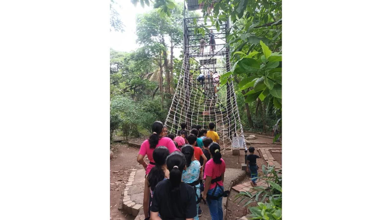Children participating in rope ladder climbing at SPJIMR summer camp 2025.